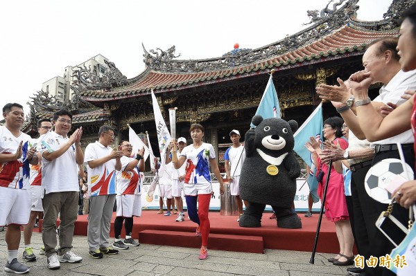 前田徑國手王惠珍（中）從龍山寺出發傳遞聖火，台北市長柯文哲（左3）等人夾道歡送。（記者陳志曲攝）