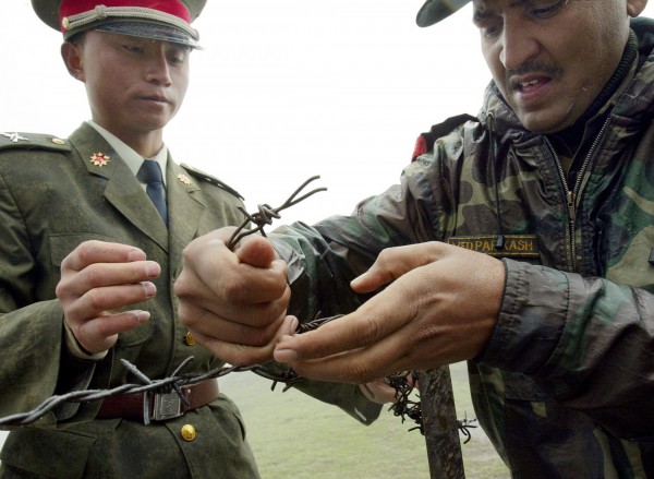 消息指出，中國與印度邊境人員在印度獨立日互換糖果，圖為2006年中印士兵共同繫圍籬的照片。（法新社）