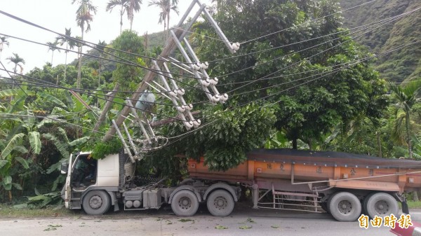 一輛砂石車閃車不慎撞倒電線桿，大半車頭被壓住，所幸駕駛及時逃出，沒有人員受傷。（記者劉濱銓攝）