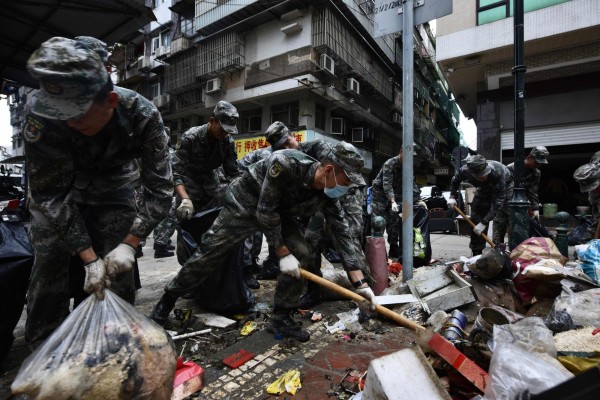 駐澳解放軍25日起在澳門參與救災，在酷熱天氣下，傳出2名軍人在協助清理現場時中暑。（法新社）