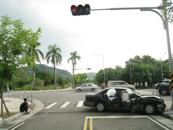 詐騙車手開車與銀色轎車擦撞後，再撞上號誌燈座。（中興警分局提供）