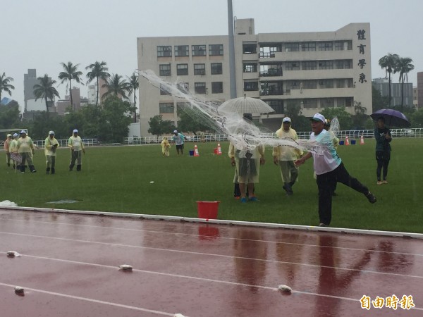 選手們雨中撒網，順利捕魚。（記者張存薇攝）