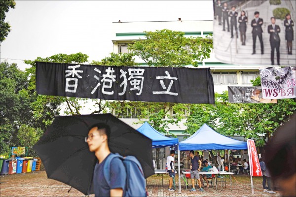 圖為中大學生七日經過校園的「香港獨立」布條。（法新社）