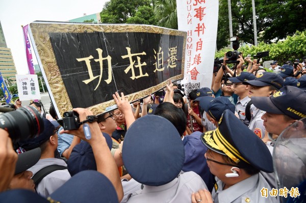 行政院今舉行新舊任院長交接典禮，台南反南鐵東移自救會等團體在行政院外召開「迎戰迫遷內閣記者會」，抗議成員準備「功在迫遷」匾額道具獻給新任行政院長賴清德，過程中與警方爆推擠衝突。（記者羅沛德攝）