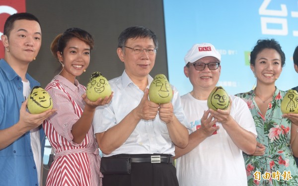 台北市長柯文哲23日至內湖美堤河濱公園，出席TLC台北野餐日，在柚子上揮灑創意畫出Q版柚子柯P，與民眾提前歡慶中秋。（記者簡榮豐攝）