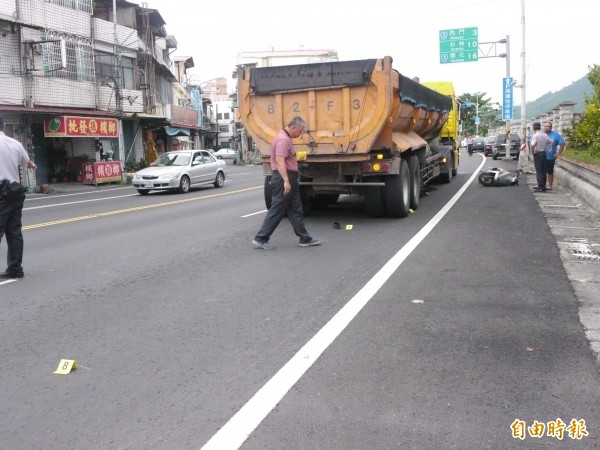 機車騎士疑突違規左轉，遭後方同行砂石車撞上，人捲入車底重傷。（記者蘇福男攝）