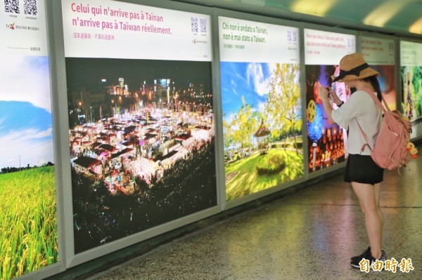 台南市觀光旅遊局在台南火車站地下道新增廣告燈箱，共有16國語言版本，美麗風光吸引遊客拍照。（記者洪瑞琴攝）