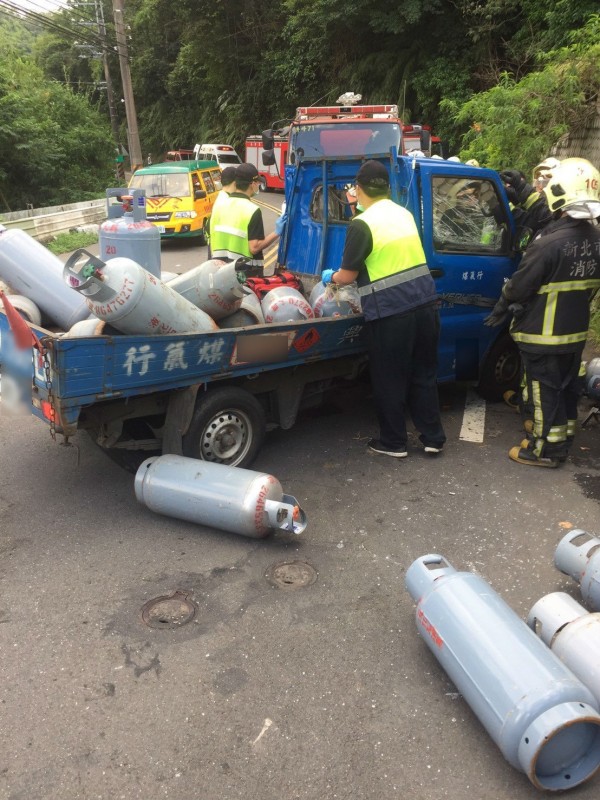 一輛載運瓦斯桶的小貨車，今天下午4點在新北市汐止區汐萬路三段與另一輛貨車發生對撞，載瓦斯的小貨車司機一度受困變形車內，造成左大腿骨折，另名駕駛頭部 4公分撕裂傷。（記者林嘉東翻攝）