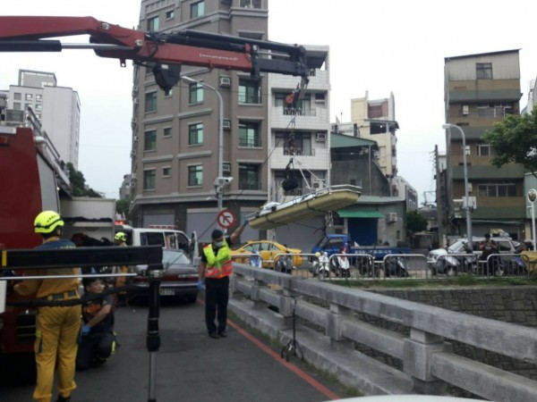 消防人員使用吊臂將遺體搬運到橋上。（記者許國楨翻攝）