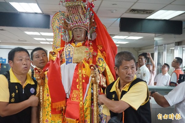 湄洲媽祖由神轎隊員抬起過台中港海關，準備搭船返回湄洲。（記者歐素美攝）