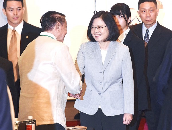 President Tsai Ing-wen, center, shakes hands with former Philippine vice president Teofisto Guingona Jr yesterday at the opening of the Yushan Forum in Taipei.
Photo: Liao Chen-huei, Taipei Times