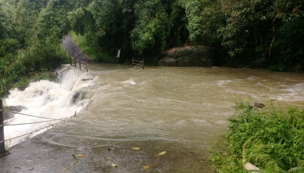 礁溪跑馬古道猴洞坑溪溪水爆漲，已越過路面，衝毀護欄。（記者江志雄翻攝）