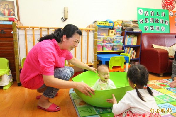 前衛生署長楊志良提議，應該讓女性服1年的「照顧役」，幫忙有需要的家庭照顧小孩。圖為保母照顧小孩。（資料照，記者洪定宏攝）