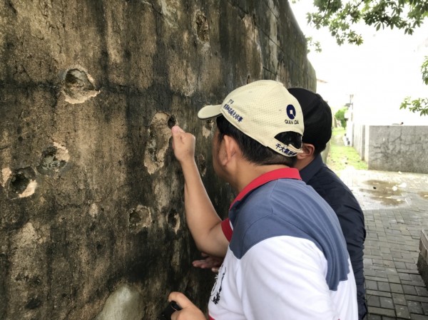 屏縣府文化處請高苑科大建築系助理教授林世超（戴白帽者）到恆春古城探勘彈孔遭填平案。（記者陳彥廷翻攝）