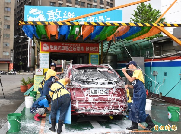 「憨樂洗車場」的憨兒們分工賣力洗車。（記者李容萍攝）