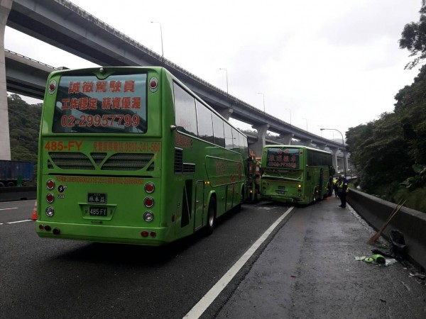 國道警方調查，今晨有輛工務車正在中外車道排除狗屍體，由陳男駕駛的統聯客運見狀急剎減速，後方由林男駕駛的統聯客運疑因未保持安全距離，加上當時天雨路滑，猛力追撞上前方的客運。（記者王宣晴翻攝）