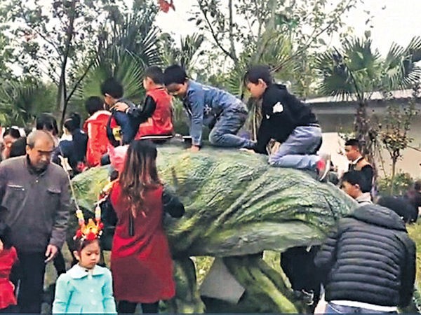 蝴蝶恐龍展上，小孩爬上恐龍背上玩耍。（圖擷取自網路影片）