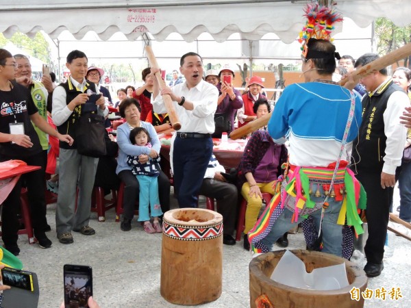 新北市副市長侯友宜體驗原住民風味的搗麻糬，須圍繞麻糬桶一面搗、一面唱歌。（記者賴筱桐攝）