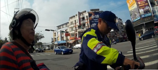 后里分駐所警員協助婦人推拋錨機車。（記者張軒哲翻攝）