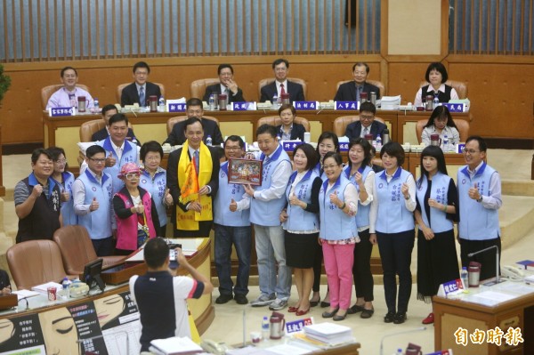 新北市議會國民黨團今天市政總質詢前，議員林金結送朱立倫代表關公的黃絲帶、媽祖金身照片及取自媽祖廟的令旗，希望朱立倫無往不利，更上層樓。（記者何玉華攝）