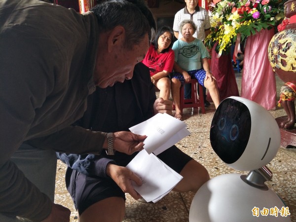 成功大學資工系教授梁勝富與盧文祥今天帶著機器人走進社區，聽取老人的需求。（記者邱灝唐攝）