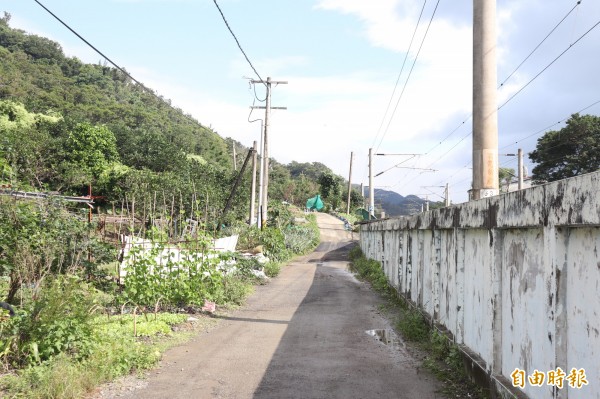 頭城鎮外澳里石空古道登山口前的約200公尺的道路，由寬僅約50公分的擋土牆構成，道路旁有種植蔬果，農民爭取將道路拓寬案，卻遲無下文。（記者林敬倫攝）