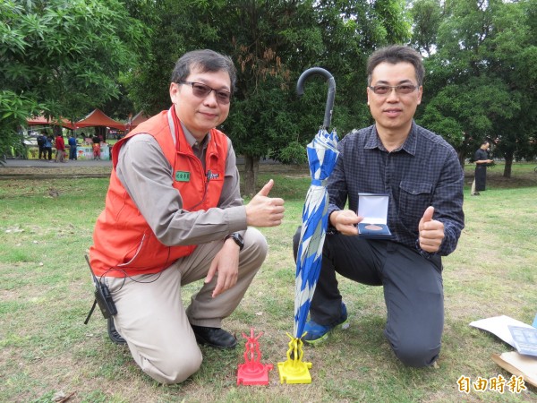 勤益科大機械系教授陳聰嘉（右）與教官蕭添進（左）合作，研發成功「迷你室內攜行集水雨傘架」。（記者蘇金鳳攝）