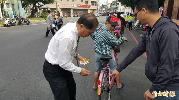 白河警分局今日結合地方活動宣導交通安全，分局長陳建民現場替高齡長輩安裝自行車後座張貼反光貼紙，老者單車夜間化身火金姑，直讚警方貼心。（記者王涵平攝）