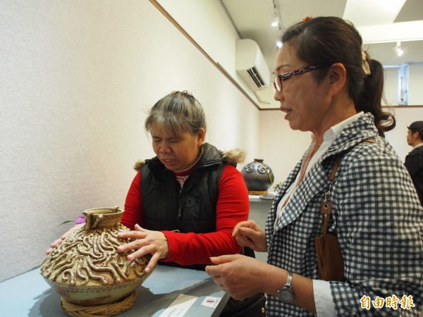 視障者透過觸覺，認識金峰鄉陶藝家麥承山的陶藝作品。（記者王秀亭攝）