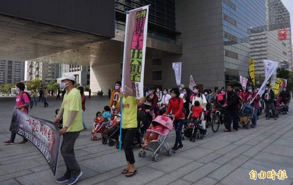 親子共學團的爸爸媽媽們推娃娃車、帶小孩繞市府抗議空污，呼籲民眾響應１２１７空污遊行。（記者蔡淑媛攝）                   