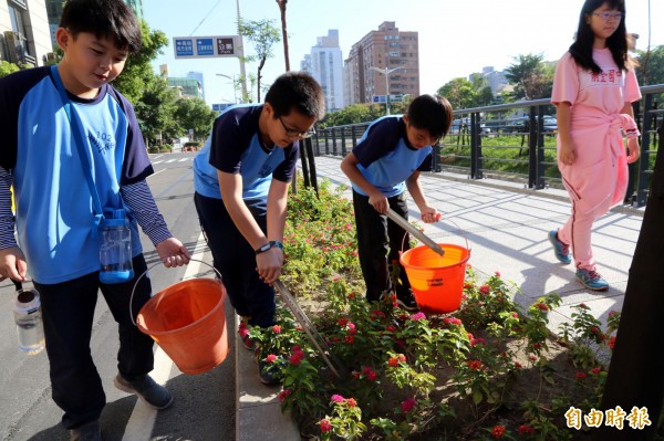 學童撿拾垃圾。（記者黃旭磊攝）