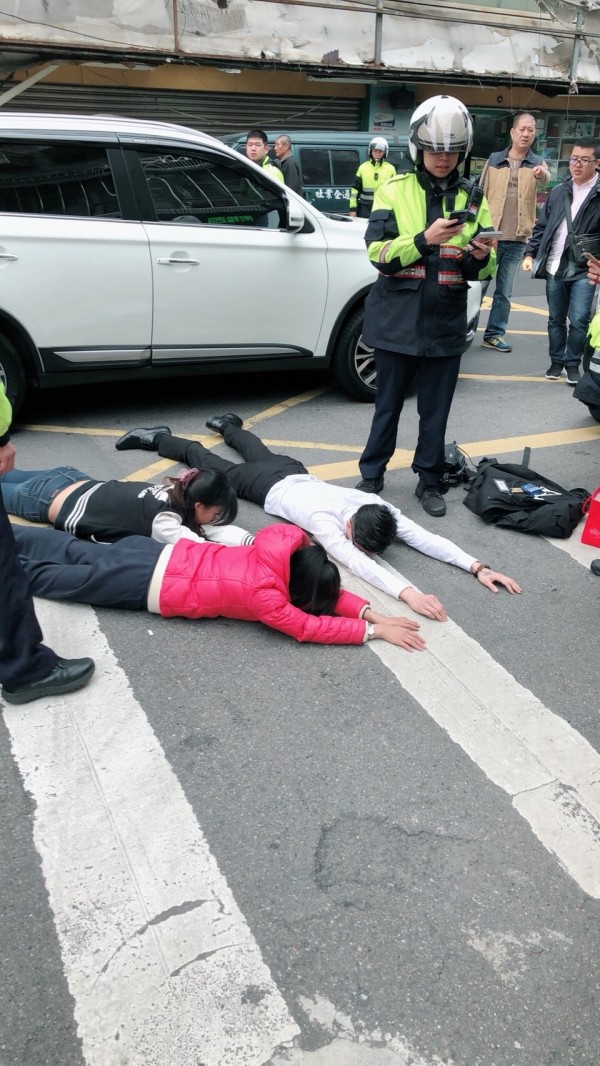 廖姓計程車司機遭強押毆打，案發後1小時嫌犯大膽開車經案發現場，被眼尖警方發現攔查壓制在地，從2人身上起出衝鋒槍、手槍與西瓜刀等物。（記者吳仁捷翻攝）