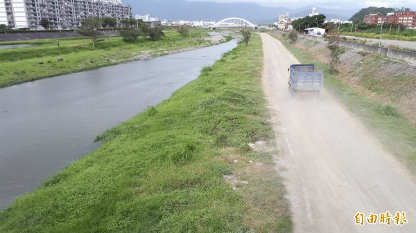 太平溪河床砂石車疾駛掀塵土，風大時會吹進河岸的東海國宅。（記者黃明堂攝）