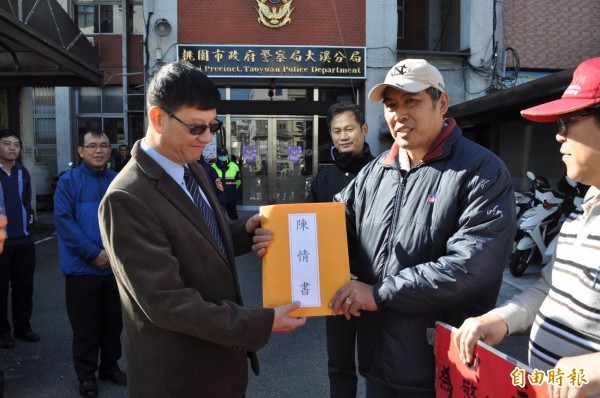 張祉道（前右二）遞交陳情書，由大溪警分局副分局長周益銘（前左一）代表收下。（記者周敏鴻攝）