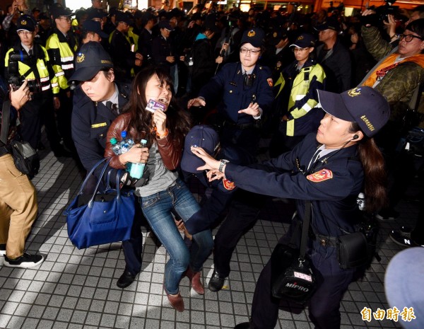 1223遊行抗議者24日凌晨遭警方驅離台北車站，抗議群眾被優勢警力帶上警備車。（記者羅沛德攝）