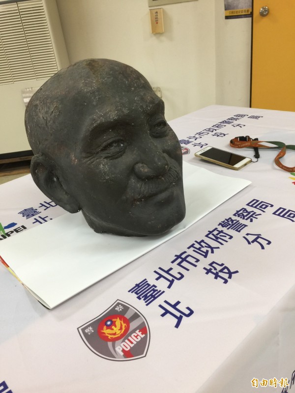 北投警方尋回中正高中遭斬首的蔣介石銅像頭，台灣建國工程隊長郭志剛手機中有犯罪照片，遭警方一併查扣。（記者陳恩惠攝）