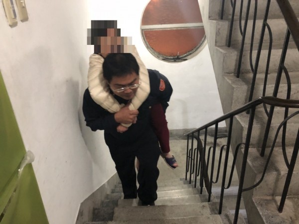 員警背老婦上樓。（記者鄭景議翻攝）