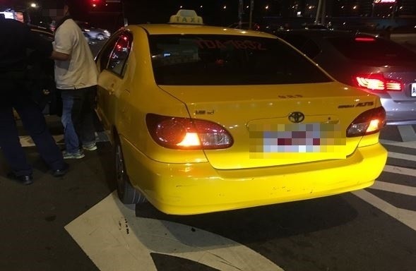 計程車司機（右）遭羅男毆打，與到場警方說明狀況。（記者陳薏云翻攝）