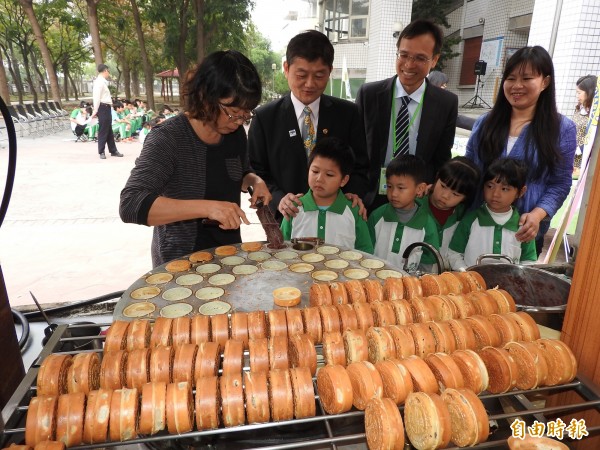 南崗扶輪社送出一個個熱騰騰的「扶輪餅」，鼓勵小朋友繼續用心閱讀學習。（記者佟振國攝）