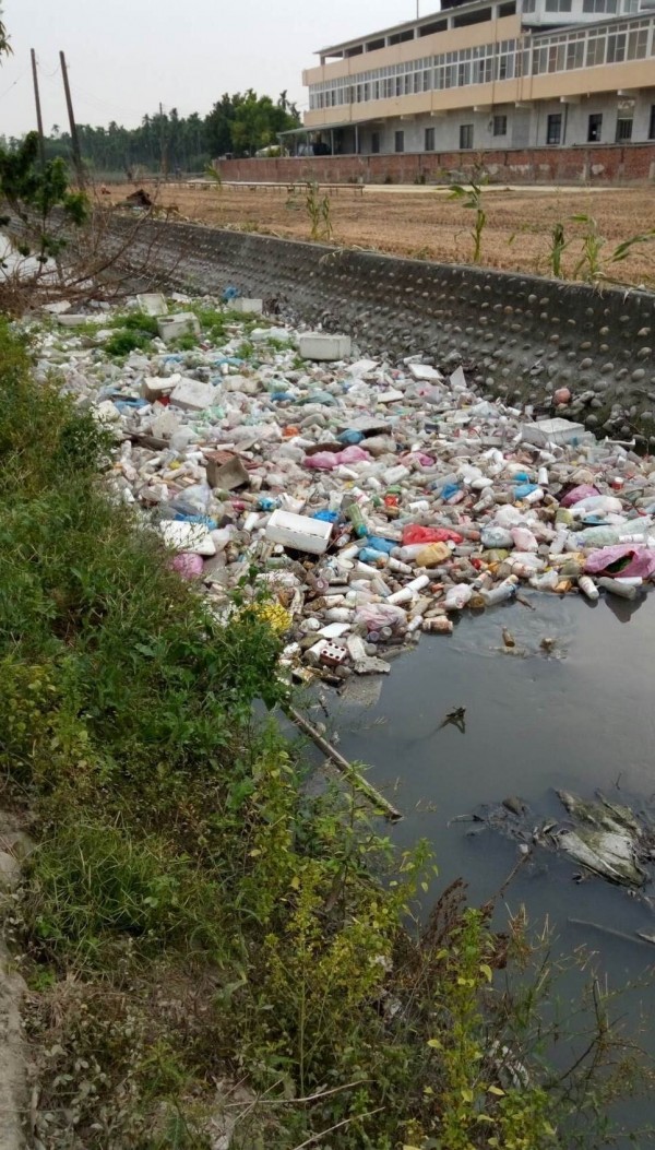 流經屏東市龍華里的灌溉大排「永安圳」，布滿大量的塑膠袋、保麗龍及保特瓶等垃圾，髒臭無比。（里長許國顯提供）