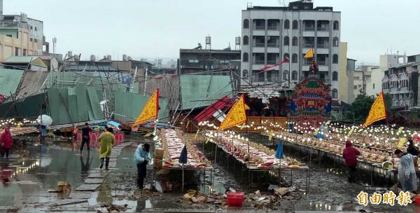 南投市建醮活動中，設在稻田的南壇，雖然不敵風雨倒塌，且會場因雨積水、泥濘，但民眾仍準備飯擔等供品祭拜，虔誠之心不受影響。（記者謝介裕攝）