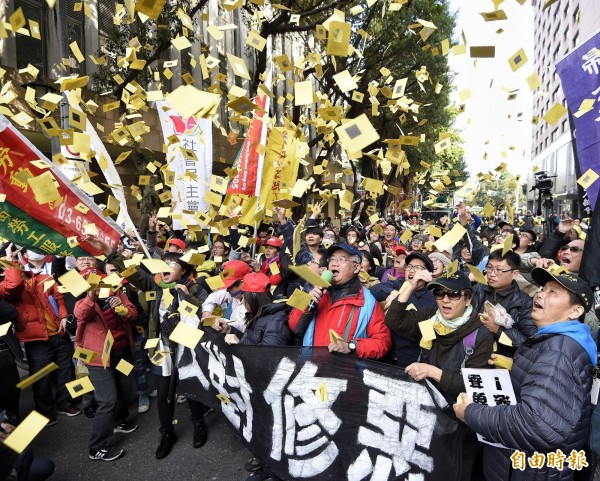 勞基法修正案今天上午三讀通過，勞團在立法院外灑冥紙抗議。（記者陳志曲攝）