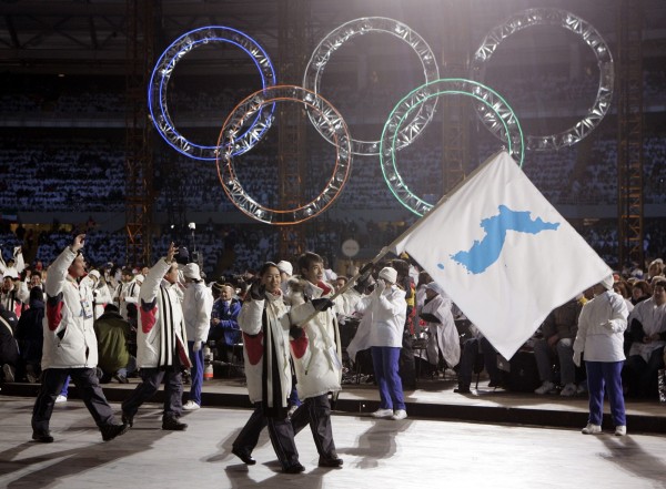 兩韓今日敲定在平昌冬奧開幕式上，舉統一旗一同入場。圖為2006年杜林冬季奧運兩韓舉統一旗共同入場。（美聯社）