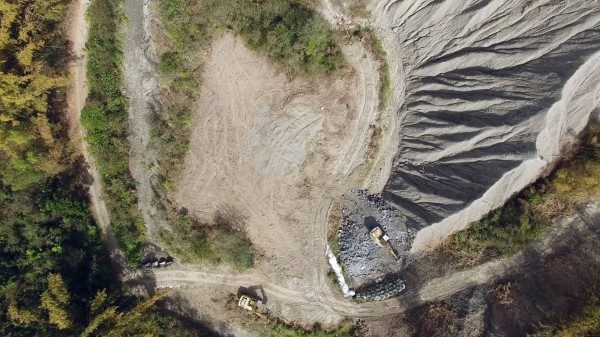 台南社大環境行動小組今天空拍龍崎掩埋場，發現怪手挖除百萬年泥岩地景，旁邊樹林也遭剷除。（台南社大提供）