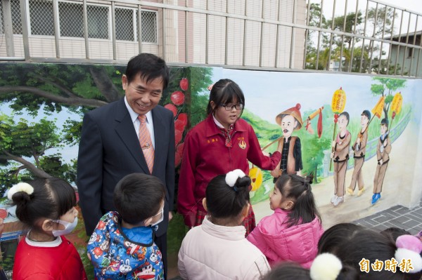 順天國中學生向幼兒園學童解說彩繪圍牆。（記者張軒哲攝）