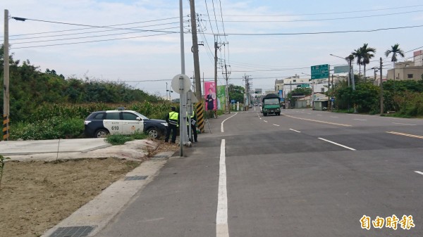 警車、警員離路口遠遠「躲」起來取締交通違規。（記者楊金城攝）