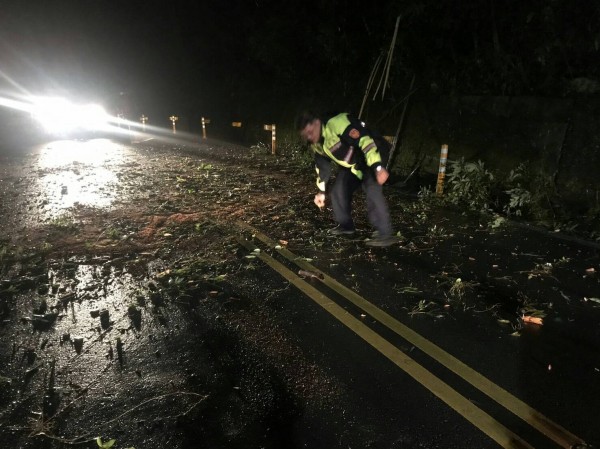 警員及消防隊員合力將大樹移除，恢復道路暢通。（記者鄭名翔翻攝）