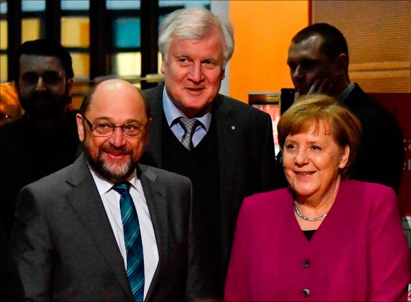 德國總理梅克爾（右）的基民盟與舒茲（左）領導的社民黨達成再次合組大聯合政府的協議。（法新社檔案照）