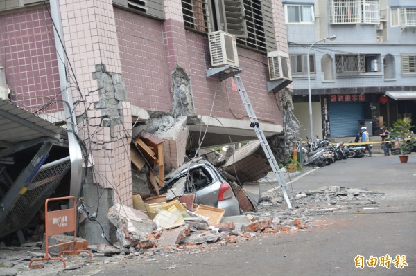 國盛六街41號吾居吾宿大樓嚴重傾斜，一樓停車場滿目瘡痍，車輛都被碎石壓毀。（記者王峻祺攝）