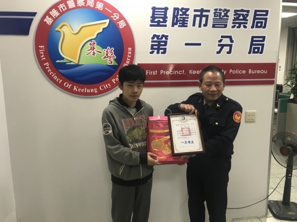 基隆市警一分局長王貴正（右）致贈見義勇為的許哲銘獎牌與水果禮盒，表彰他的義行。（記者林嘉東翻攝）